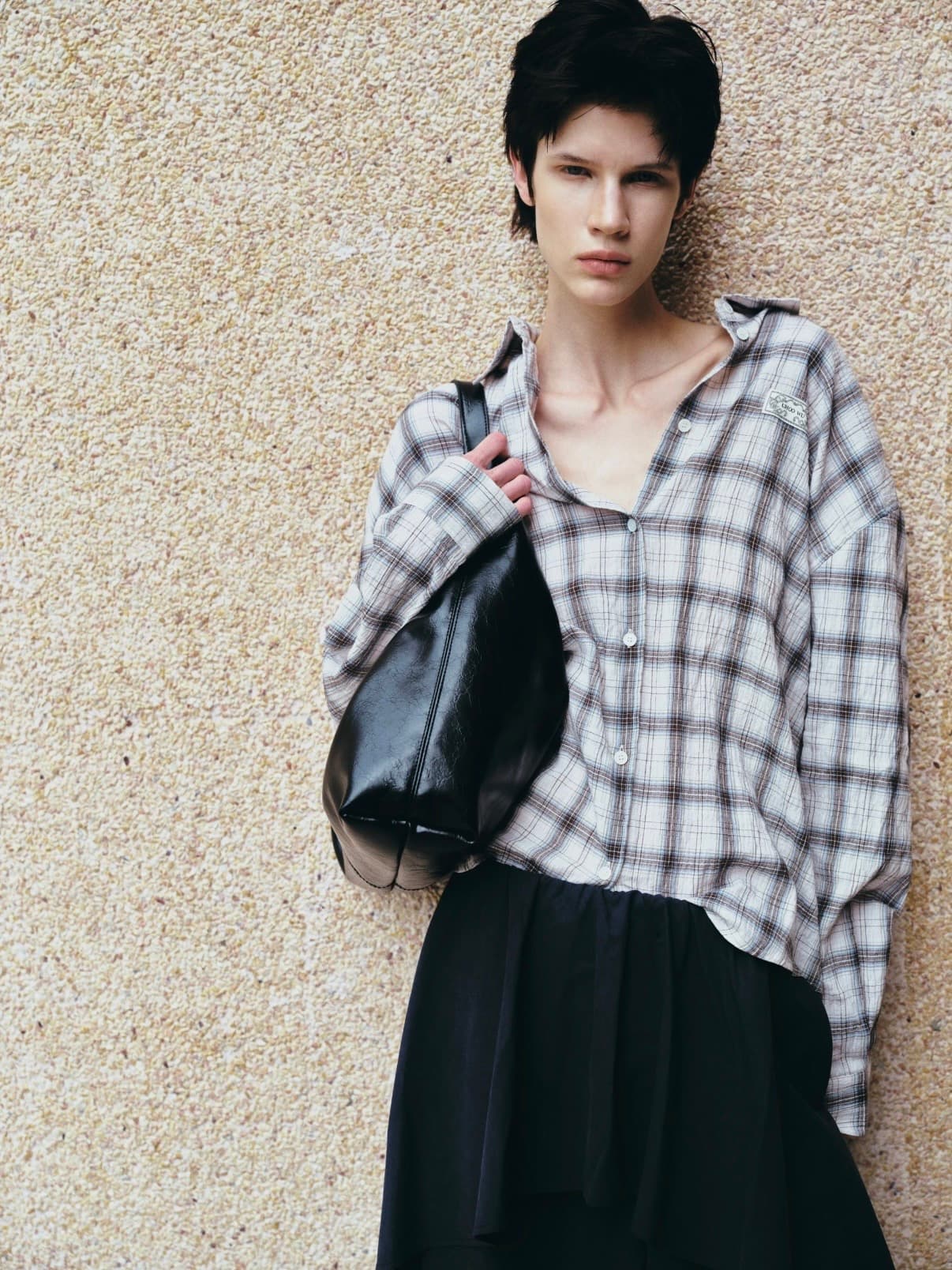 Gentle Authority portrait with checked shirt and black bag