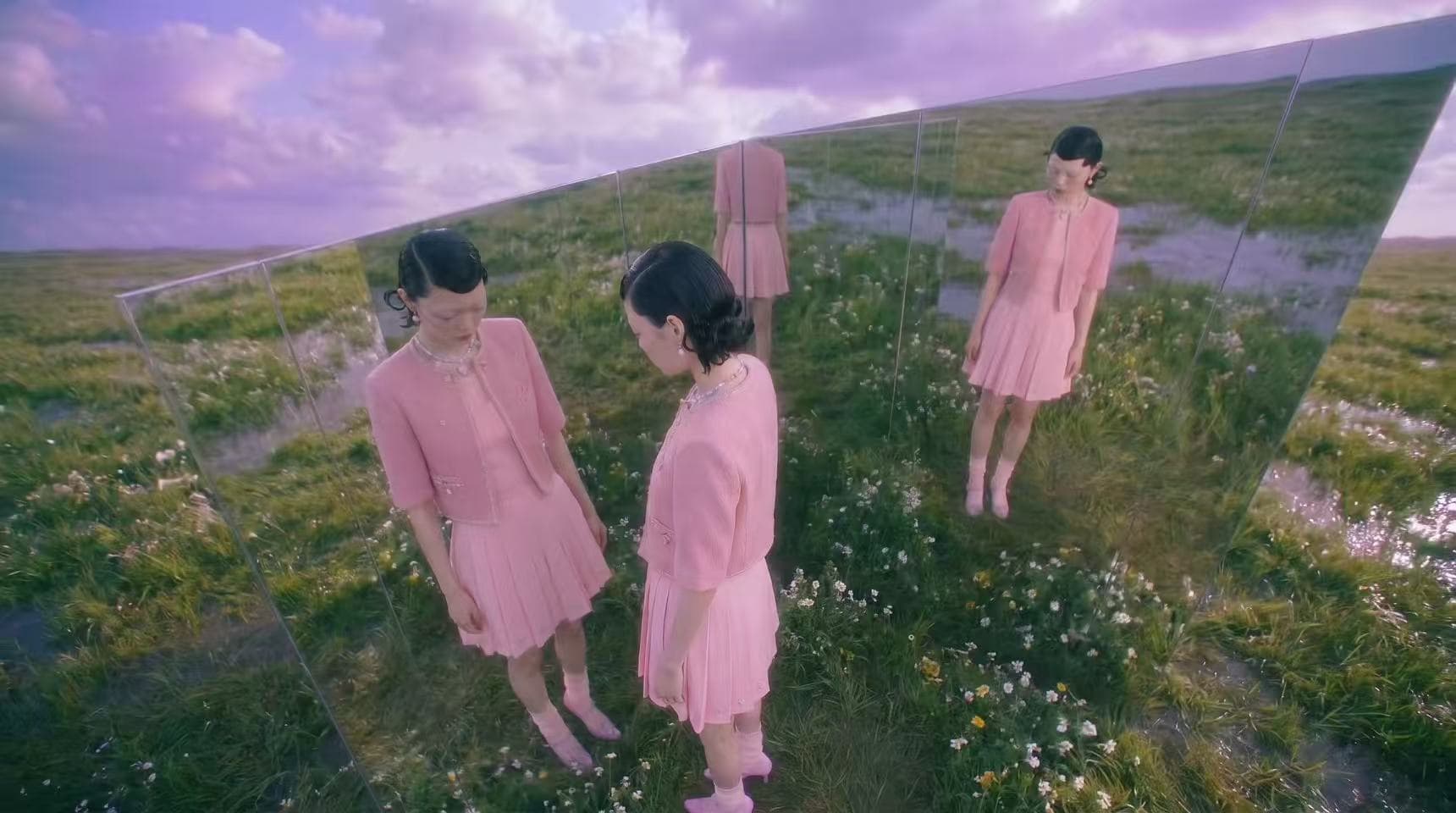 Model reflected in a slanted mirror among flowers and grass