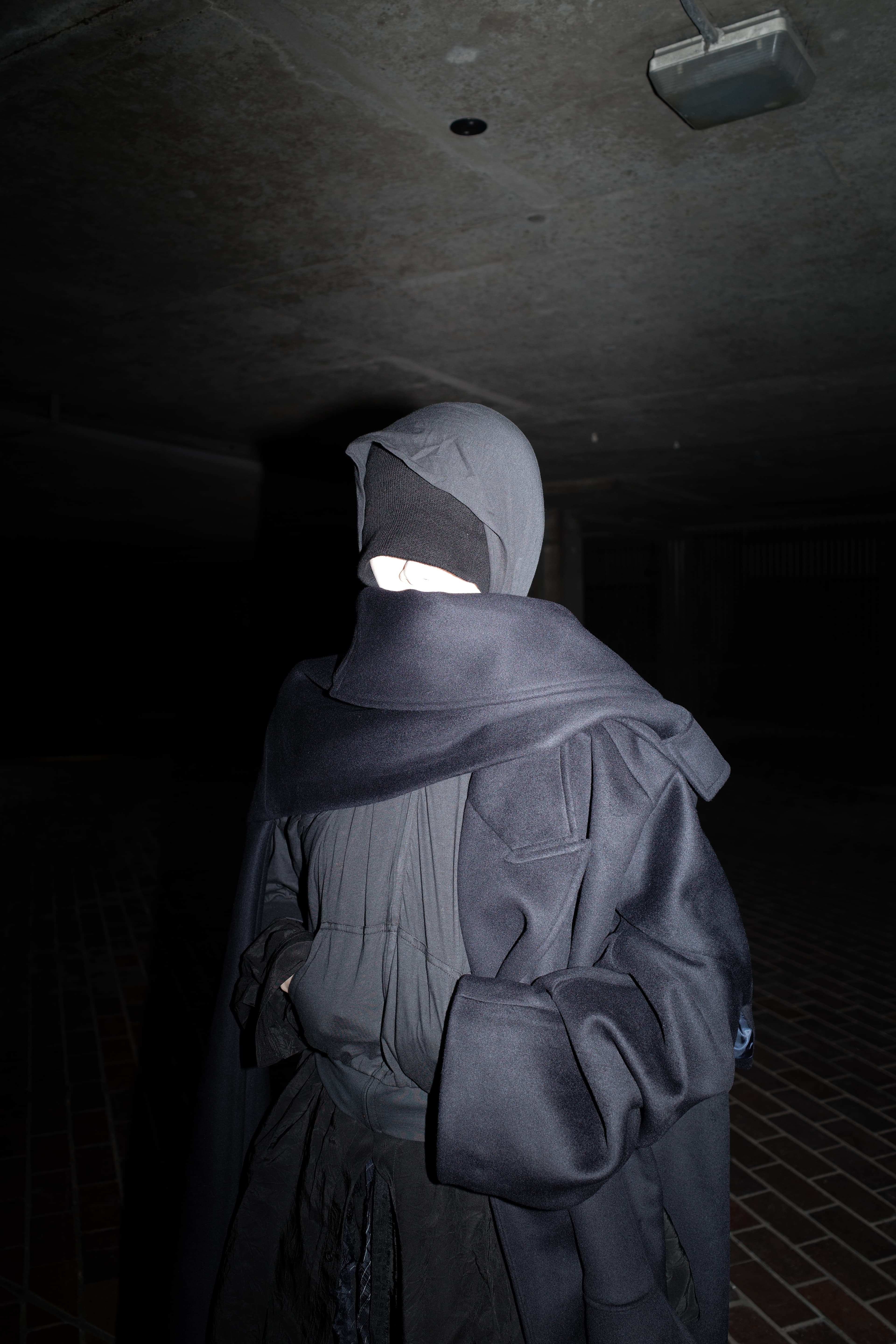 Invisible Armour portrait in a dark architectural passage