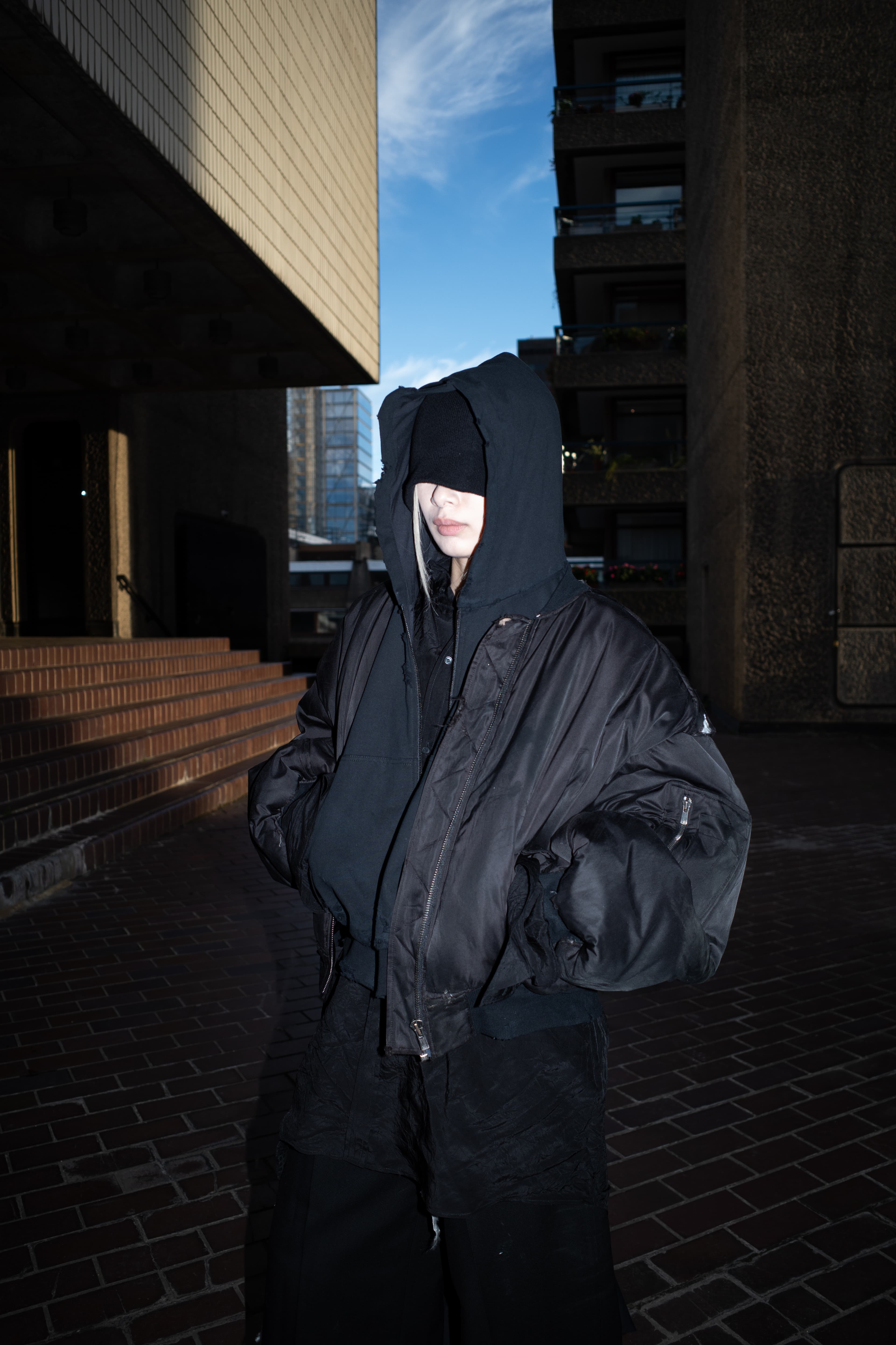 Invisible Armour standing between concrete buildings